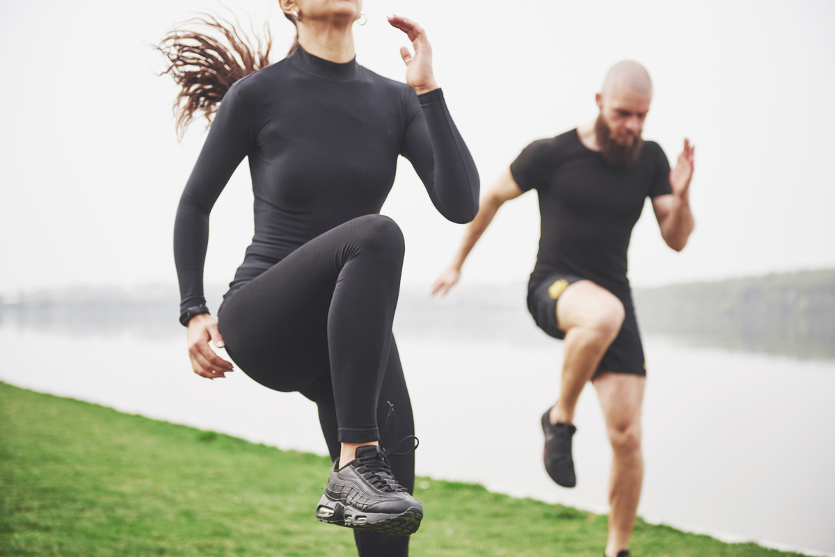 Un jeune couple aime faire du sport le matin en plein air. Échauffez-vous avant l'exercice.