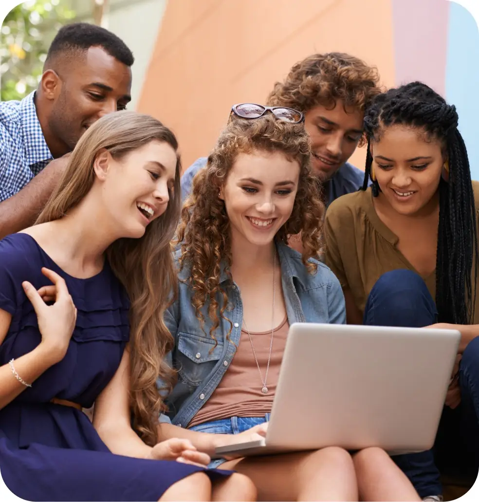 Un groupe d'étudiant qui regardent l'écran d'un ordinateur portable et qui sourient