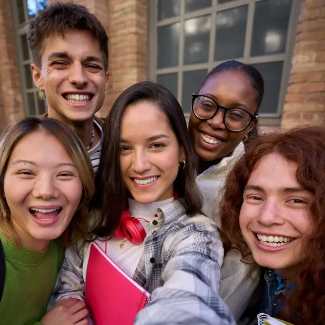 Un groupe d'étudiants qui se prennent en selfie en photo et qui sourient